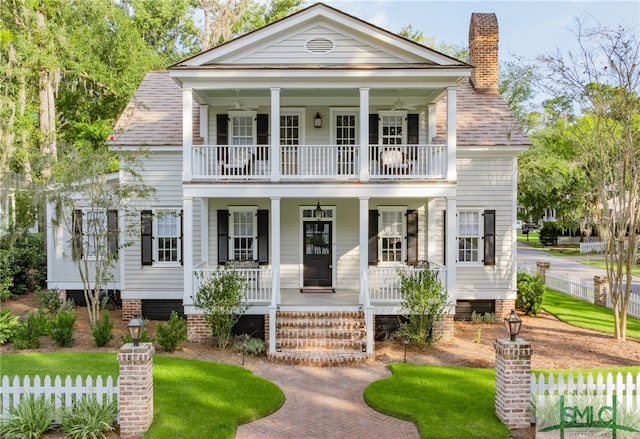 greek revival inspired property with a balcony and a porch