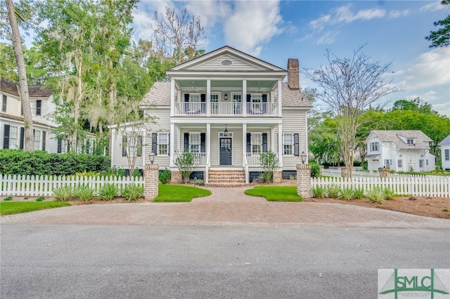 neoclassical / greek revival house featuring a balcony and covered porch