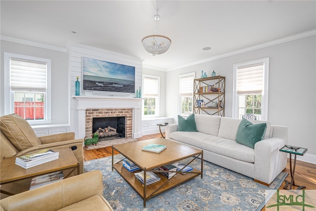 living room featuring ornamental molding, a fireplace, a chandelier, and hardwood / wood-style floors