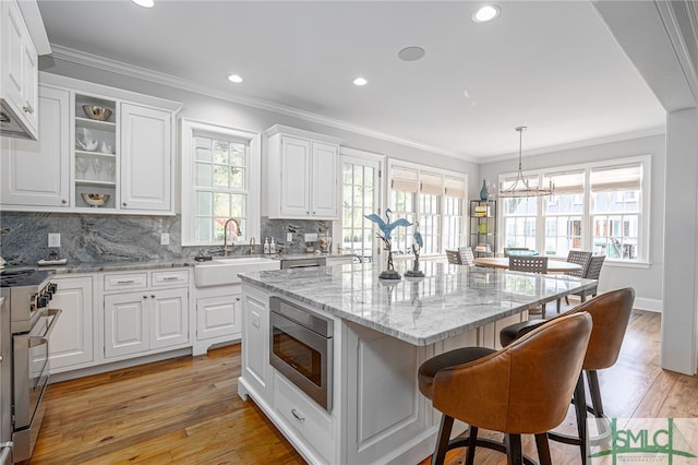 kitchen featuring stainless steel appliances, light hardwood / wood-style floors, plenty of natural light, and sink