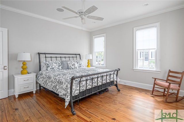 bedroom featuring multiple windows, crown molding, ceiling fan, and hardwood / wood-style flooring