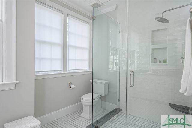 bathroom featuring tile patterned flooring, a shower with shower door, a healthy amount of sunlight, and toilet