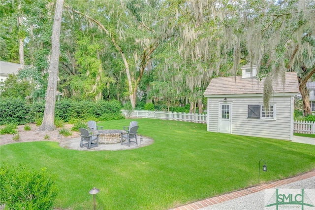 view of yard featuring a patio, an outbuilding, and a fire pit