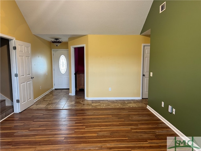 entrance foyer featuring dark hardwood / wood-style flooring and lofted ceiling