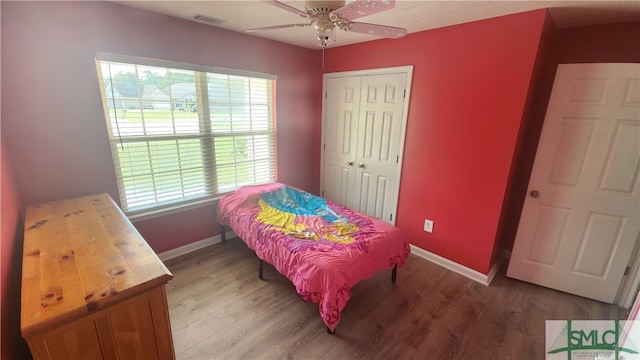 bedroom featuring ceiling fan, wood-type flooring, and a closet