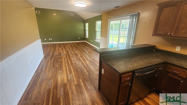 kitchen featuring dark wood-type flooring, kitchen peninsula, vaulted ceiling, and dishwasher