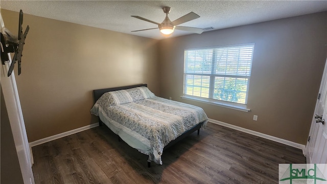 bedroom with a textured ceiling, dark wood-type flooring, and ceiling fan