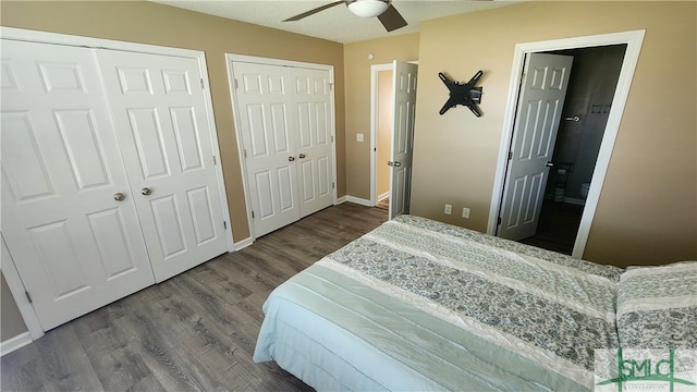 bedroom featuring a textured ceiling, ensuite bathroom, ceiling fan, dark hardwood / wood-style floors, and multiple closets