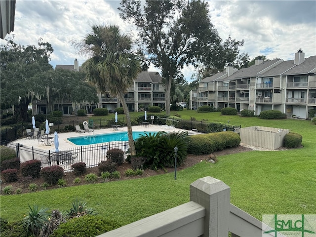 view of swimming pool with a yard