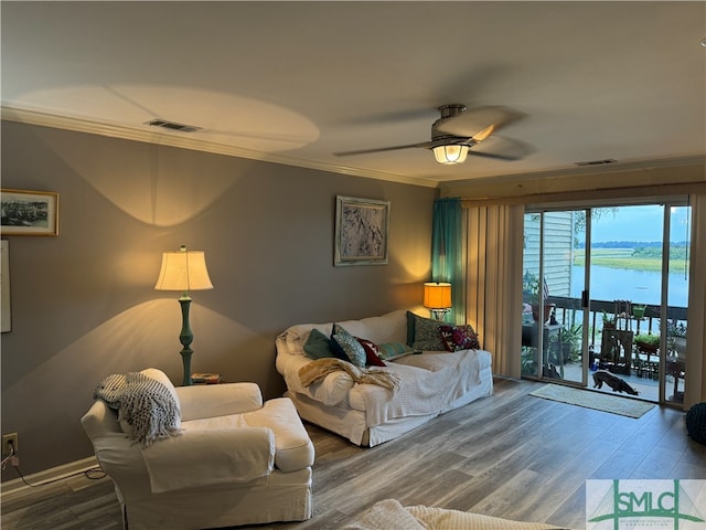 living room with ceiling fan, hardwood / wood-style floors, a water view, and crown molding