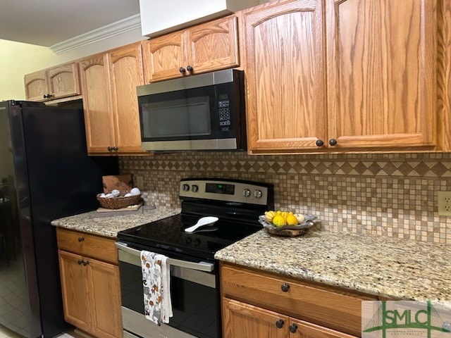 kitchen with light stone counters, crown molding, stainless steel appliances, and tasteful backsplash