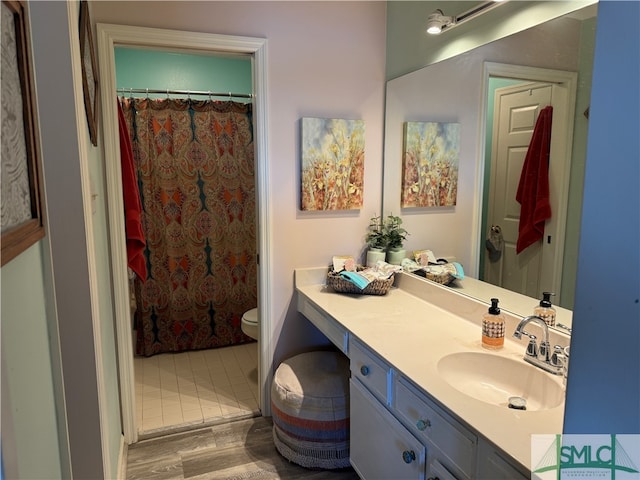 bathroom with a shower with curtain, hardwood / wood-style floors, vanity, and toilet