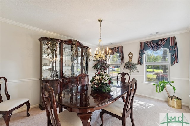 dining space with ornamental molding, a chandelier, and carpet