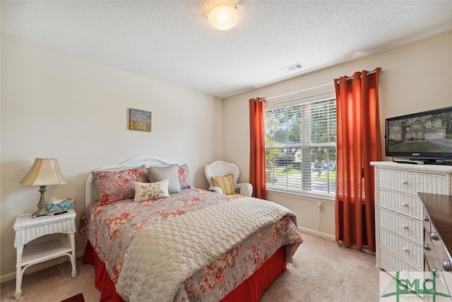 bedroom featuring light carpet and a textured ceiling