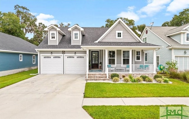 view of front of house with a porch, a garage, and a front lawn