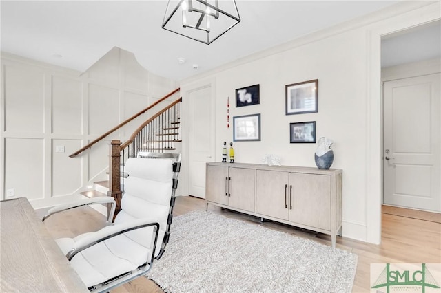 stairway featuring ornamental molding, a notable chandelier, and hardwood / wood-style flooring