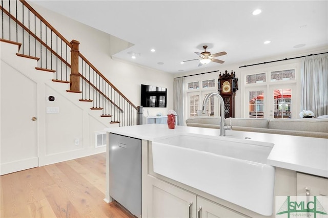 kitchen with ceiling fan, dishwasher, sink, light hardwood / wood-style floors, and white cabinets