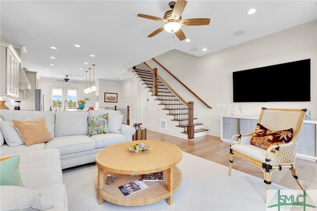 living room with french doors, light wood-type flooring, and ceiling fan