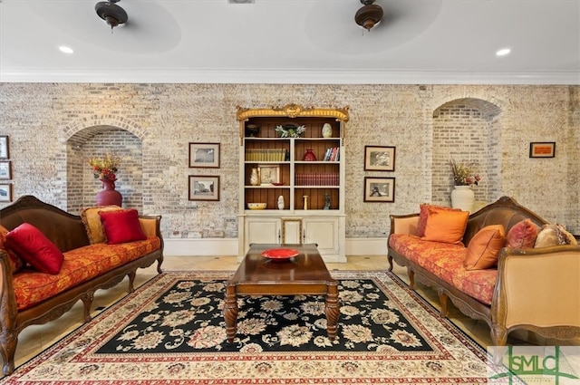 living area with ceiling fan, crown molding, and light tile patterned floors