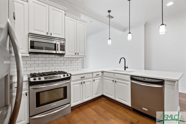 kitchen with white cabinets, stainless steel appliances, dark hardwood / wood-style floors, and kitchen peninsula