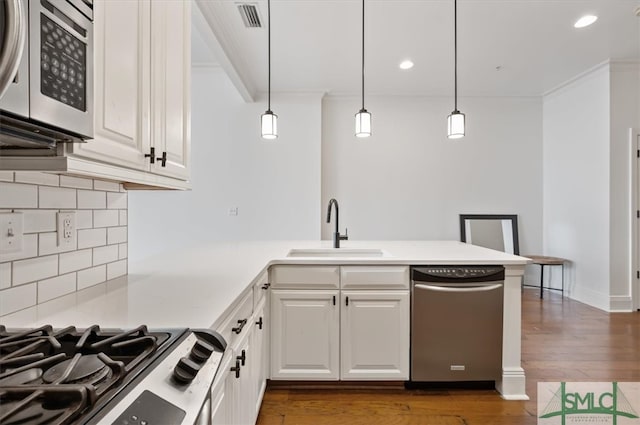 kitchen with stainless steel appliances, white cabinets, dark hardwood / wood-style floors, and decorative light fixtures