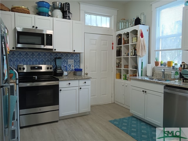 kitchen featuring white cabinetry, appliances with stainless steel finishes, and a healthy amount of sunlight