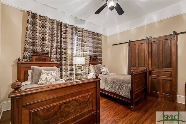 bedroom featuring ceiling fan, a barn door, and dark wood-type flooring