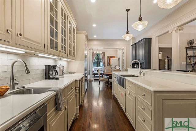 kitchen featuring a kitchen island with sink, decorative light fixtures, sink, and dark hardwood / wood-style flooring