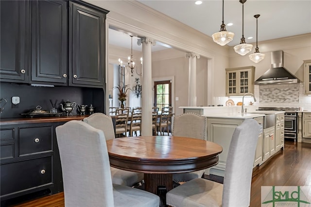 dining area featuring ornamental molding, dark hardwood / wood-style floors, sink, and a notable chandelier