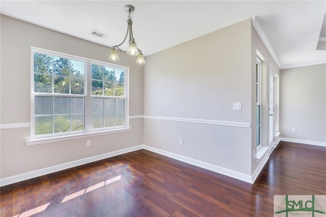 unfurnished room featuring a notable chandelier, ornamental molding, and dark wood-type flooring