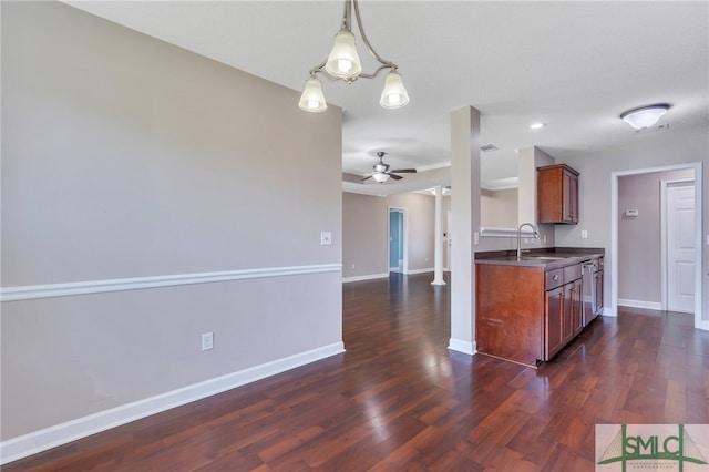 kitchen with ceiling fan with notable chandelier, dark hardwood / wood-style flooring, pendant lighting, and sink