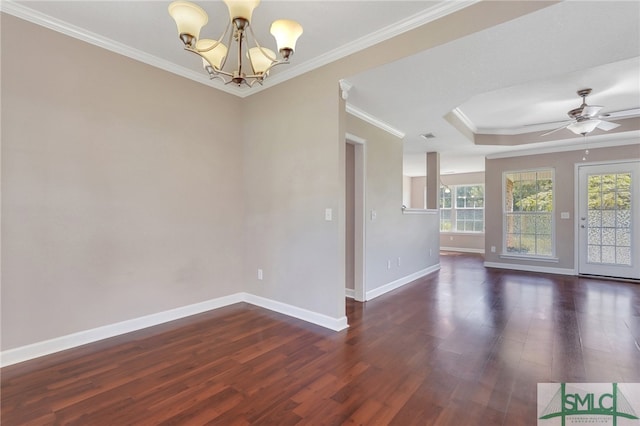 spare room featuring ornamental molding, a wealth of natural light, ceiling fan with notable chandelier, and dark wood-type flooring