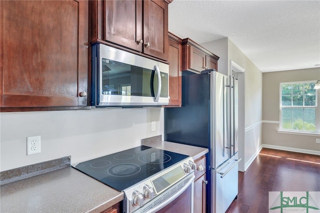 kitchen featuring electric range oven, a textured ceiling, and dark hardwood / wood-style floors