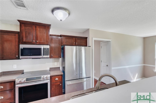 kitchen featuring a textured ceiling and appliances with stainless steel finishes