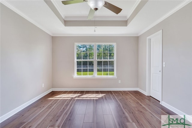 spare room featuring ceiling fan, ornamental molding, a tray ceiling, and light hardwood / wood-style floors