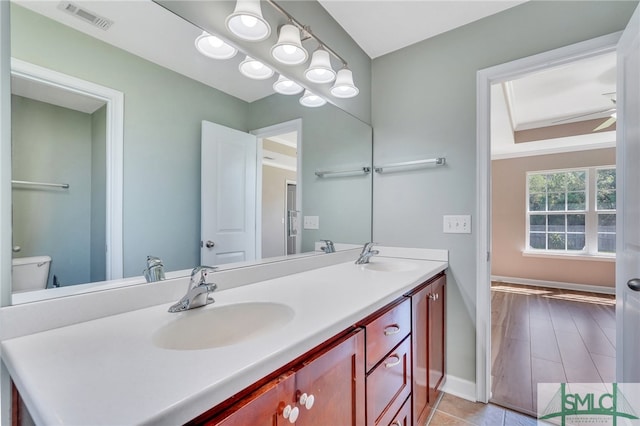 bathroom with vanity, toilet, and hardwood / wood-style flooring