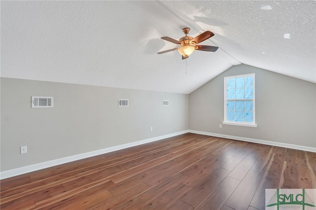 additional living space featuring vaulted ceiling, a textured ceiling, hardwood / wood-style flooring, and ceiling fan