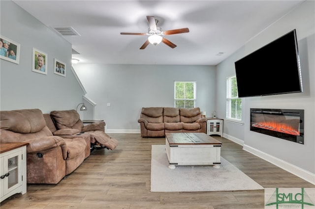 living room featuring ceiling fan and light hardwood / wood-style flooring