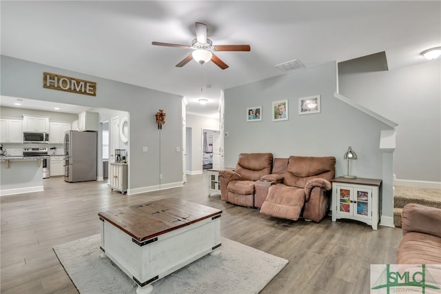 living room featuring light wood-type flooring and ceiling fan