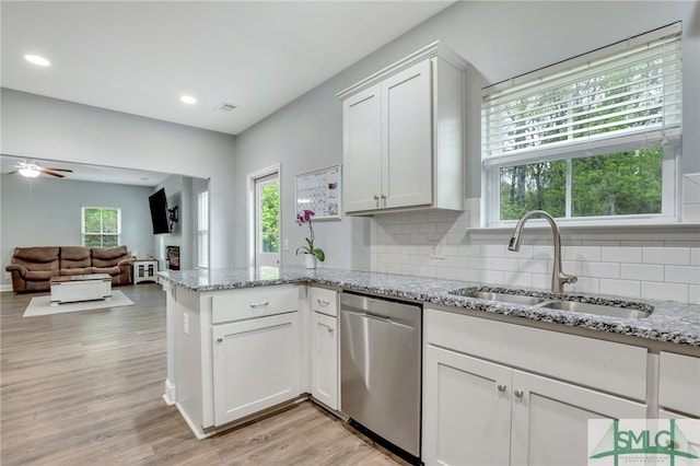 kitchen featuring sink, backsplash, white cabinetry, dishwasher, and light wood-type flooring