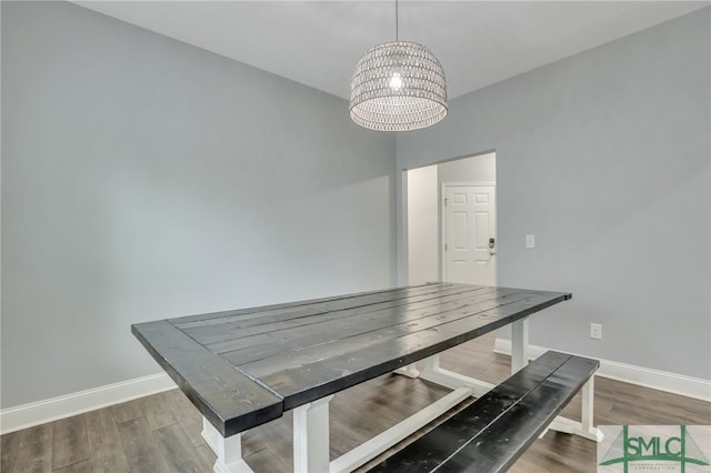 dining room featuring wood-type flooring and an inviting chandelier