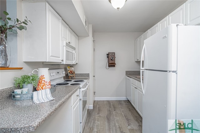 kitchen with light wood-type flooring, white appliances, and white cabinets