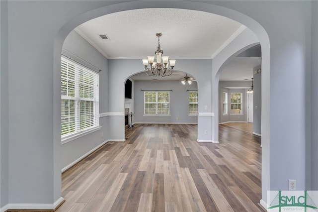 unfurnished dining area with hardwood / wood-style flooring, a textured ceiling, and a wealth of natural light