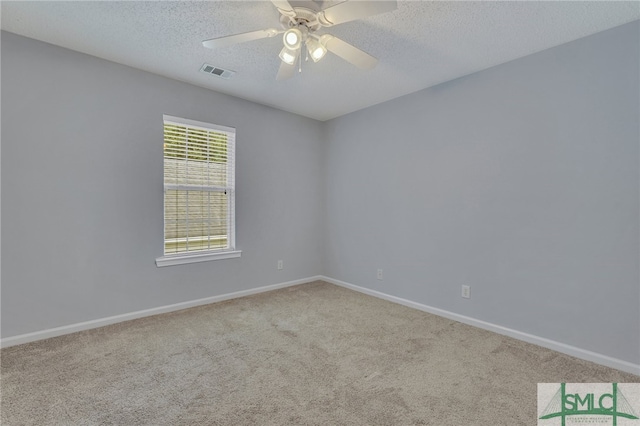 carpeted empty room featuring ceiling fan and a textured ceiling