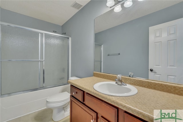 full bathroom featuring a textured ceiling, combined bath / shower with glass door, vanity, and toilet