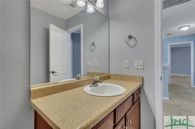 bathroom featuring a textured ceiling and vanity