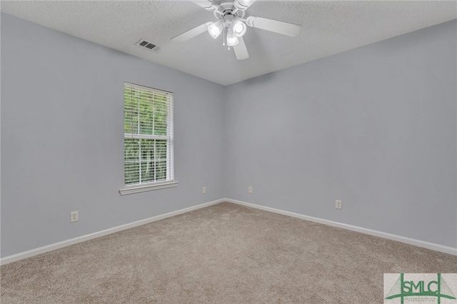 carpeted empty room featuring ceiling fan and a textured ceiling