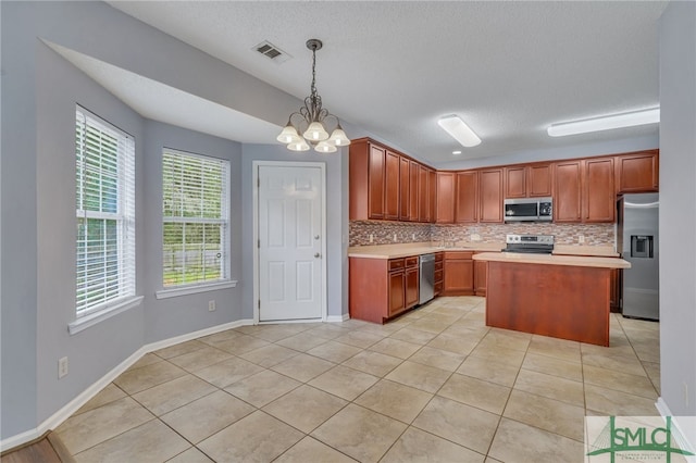 kitchen featuring decorative light fixtures, backsplash, appliances with stainless steel finishes, a center island, and an inviting chandelier