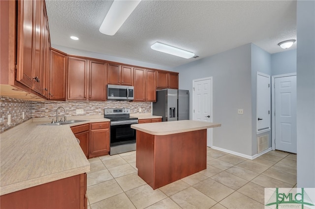 kitchen featuring tasteful backsplash, a kitchen island, stainless steel appliances, a textured ceiling, and sink