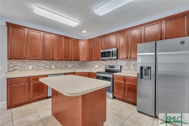 kitchen with appliances with stainless steel finishes, backsplash, light tile patterned floors, and a center island